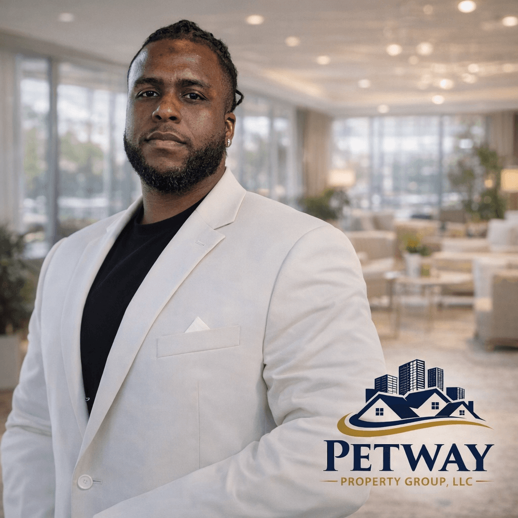 Professional Black man in a white blazer posing with Petway Property Group real estate logo.