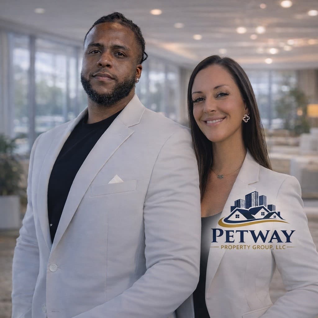 A Black man and white woman in white blazers pose for Petway Property Group.